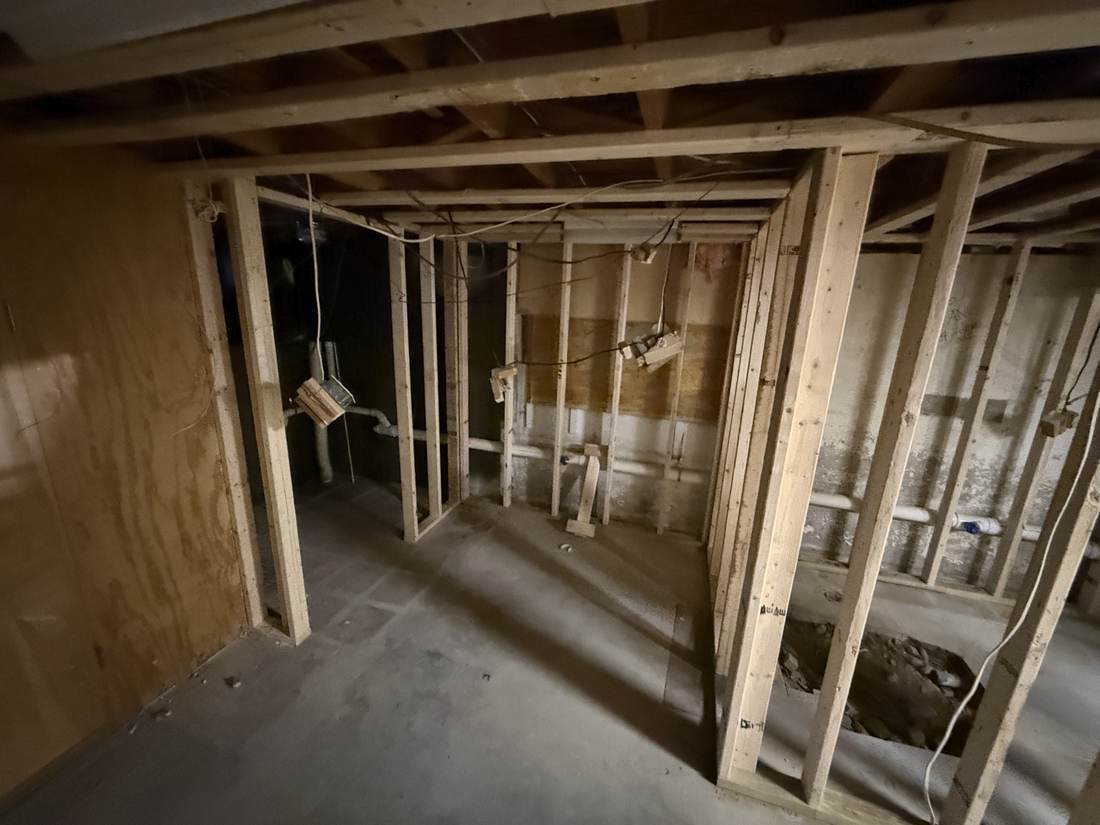 New wood-framed walls dividing a basement into rooms