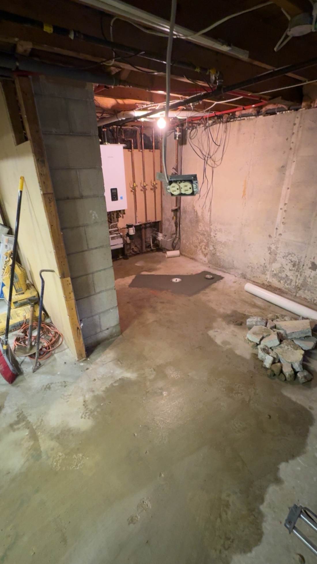 Basement utility room with water heater and block wall
