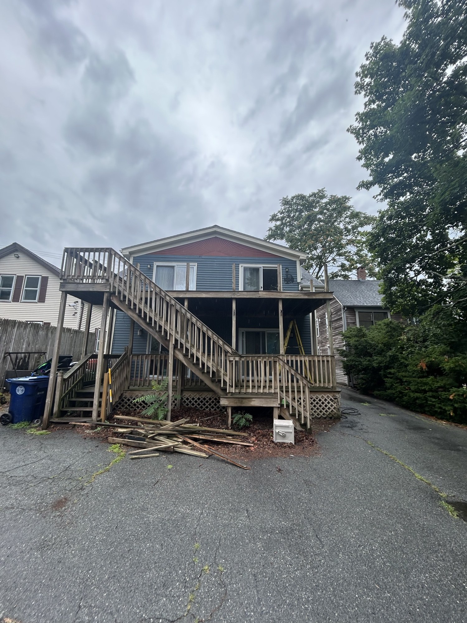Rear of the house with the original wood second-story deck and stairs