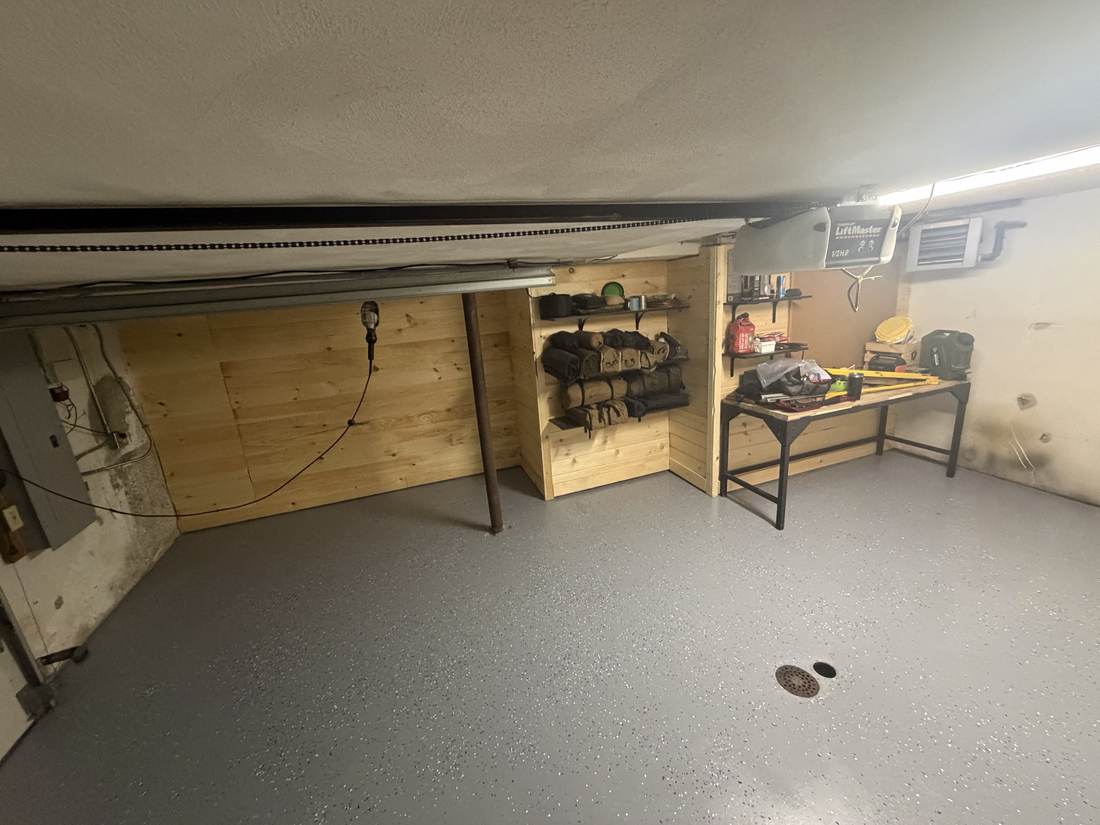 Finished garage with storage shelving and workbench, full room view