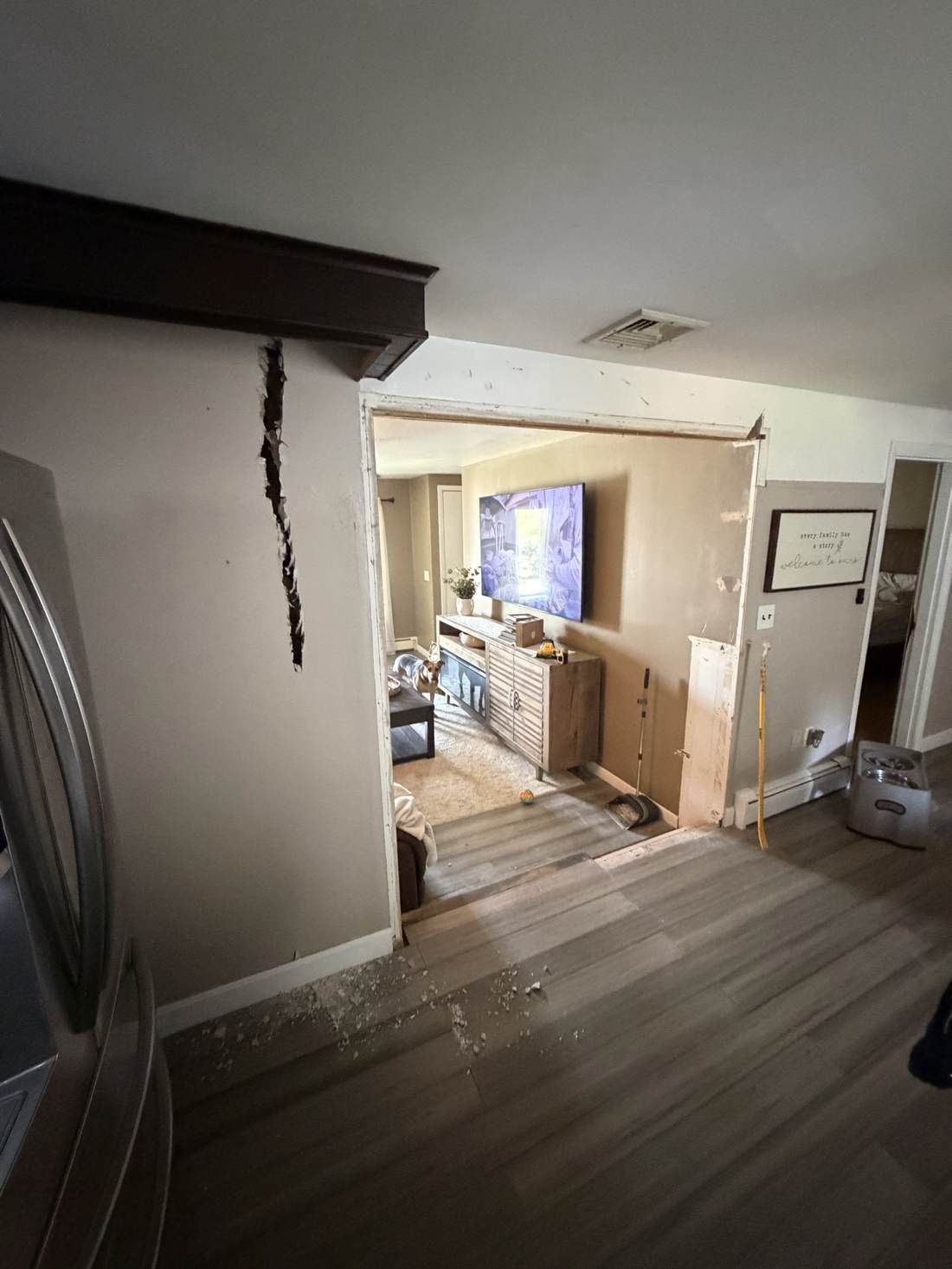 Kitchen wall opened to living room, mid-renovation with new flooring